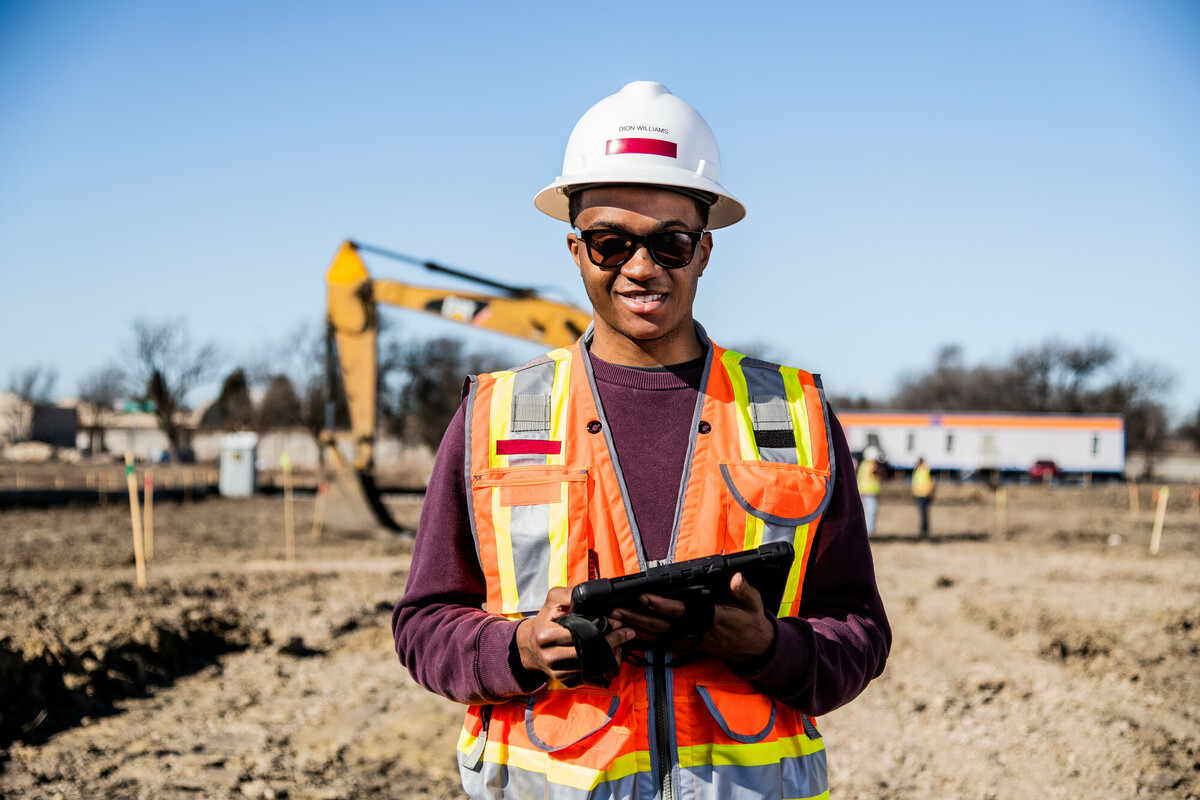 A male student standing in front of a construction site