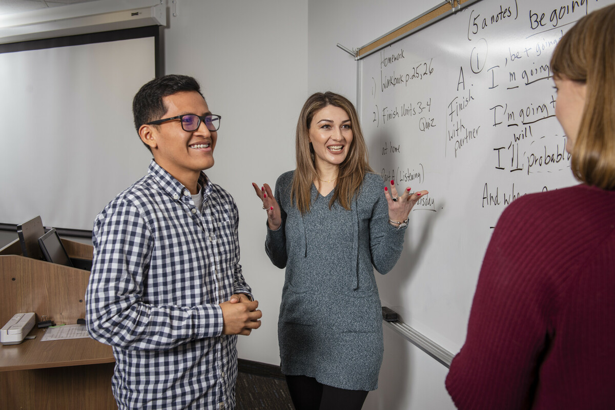 An instructor assisting two ESL students in class