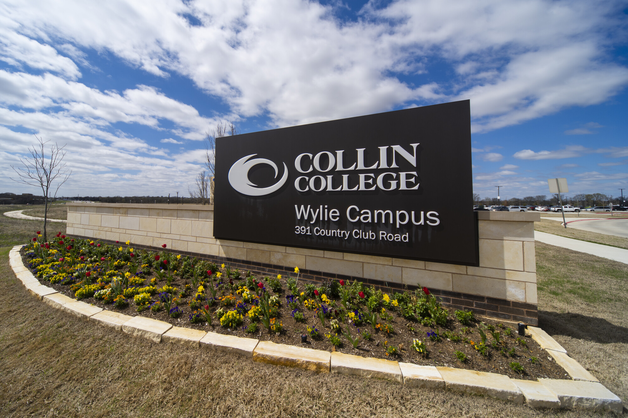 The monument sign for Wylie Campus with tulips at its base. 