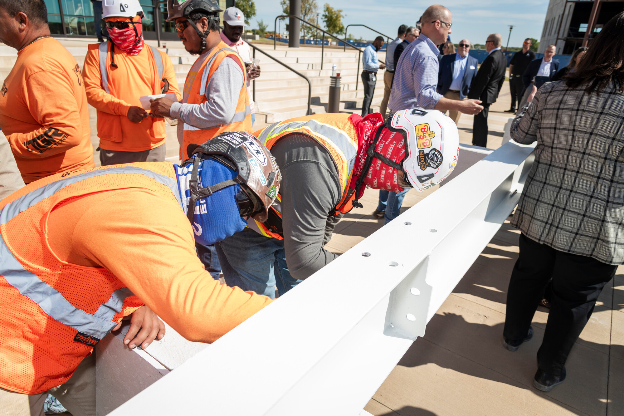 construction men in orange sign steel beam