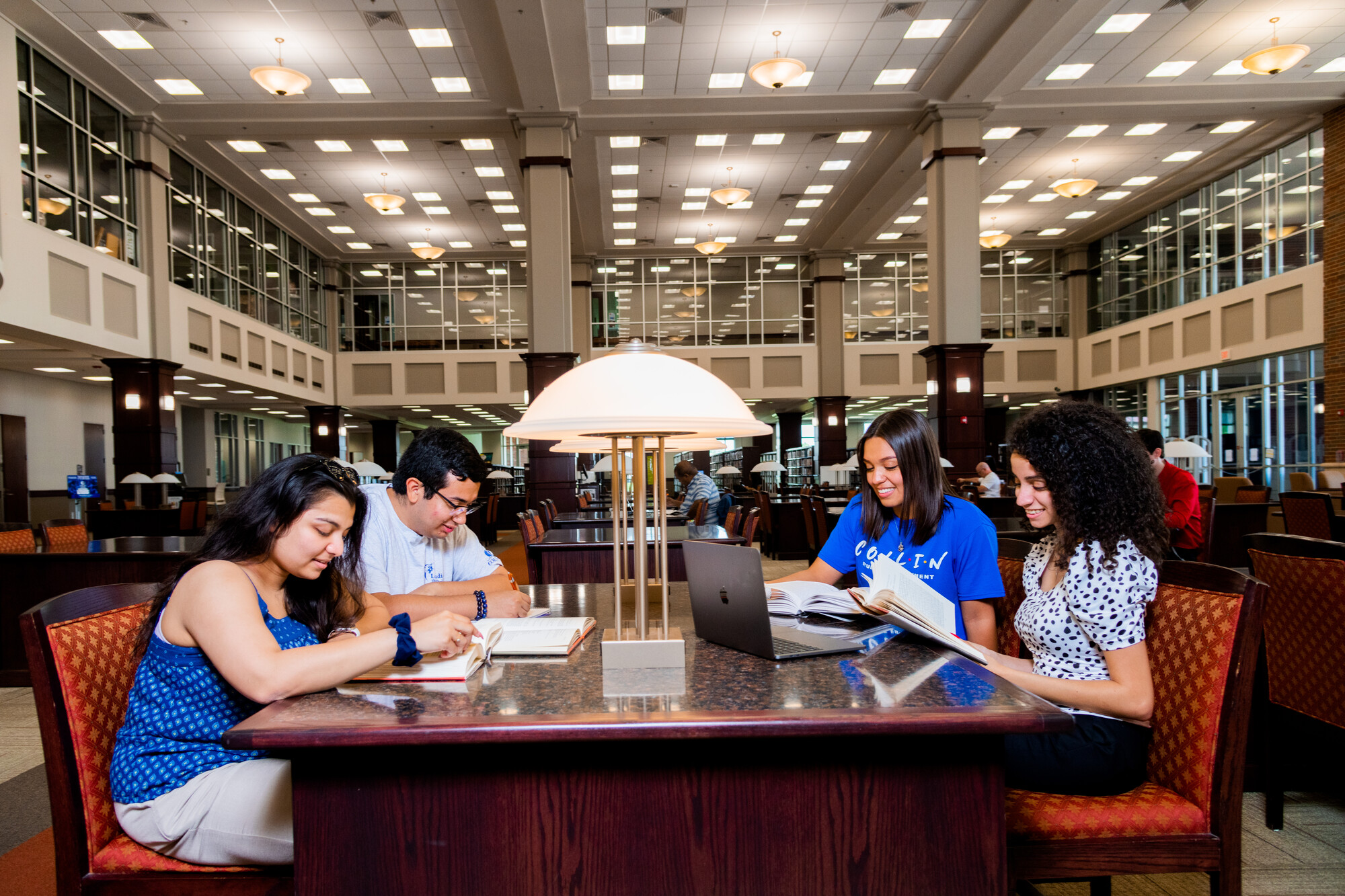 students reading at library desk 