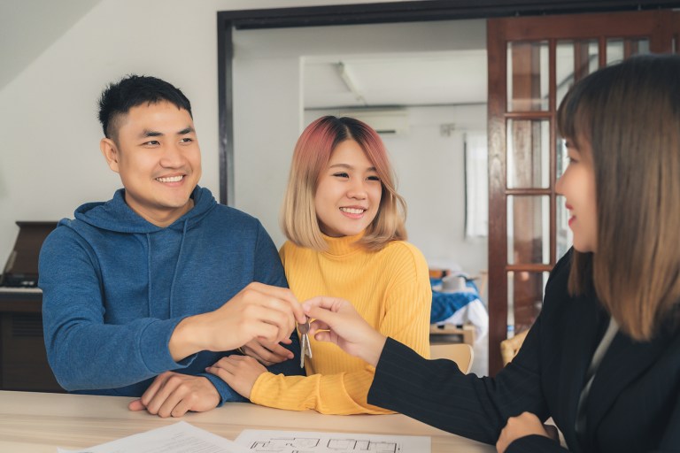 realtor gives keys to couple