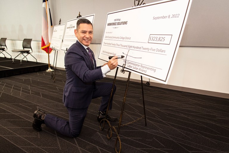 Julian Alvarez, Commissioner Representing Labor, signs the Texas Workforce Commission Skills Development Fund Grant check. Photo by Nick Young, Collin College photographer